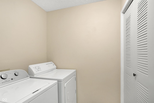 laundry area with a textured ceiling and washer and clothes dryer