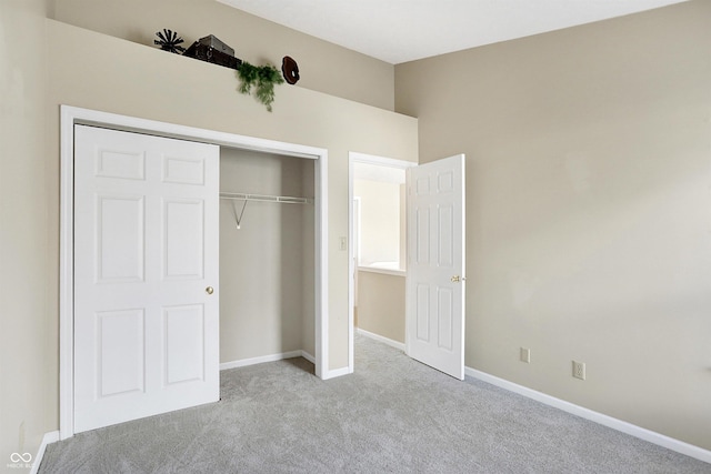 unfurnished bedroom featuring light carpet and a closet