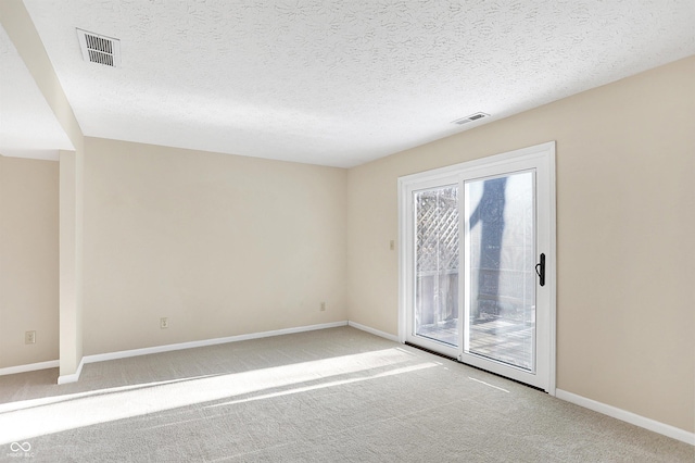 spare room featuring carpet flooring and a textured ceiling