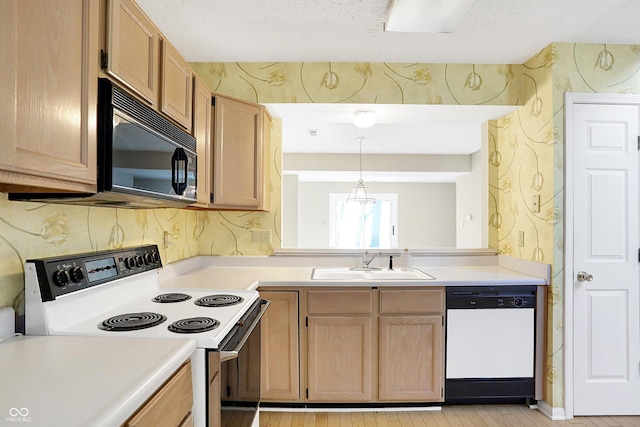 kitchen featuring a textured ceiling, sink, decorative light fixtures, and white appliances