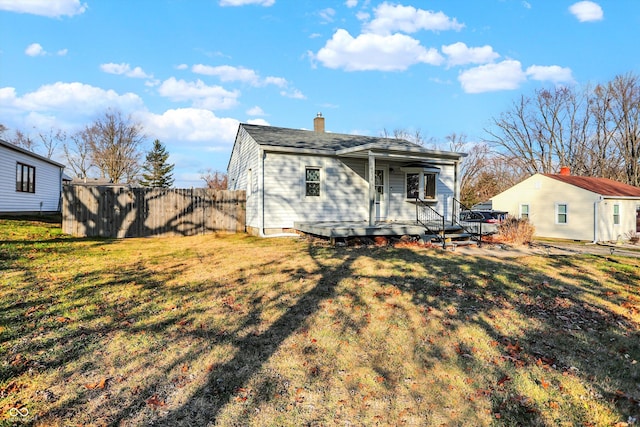 rear view of property featuring a lawn