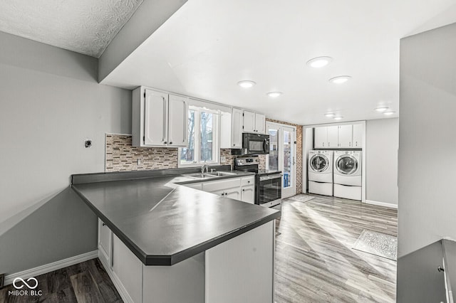 kitchen with white cabinetry, sink, kitchen peninsula, stainless steel electric stove, and washer and clothes dryer