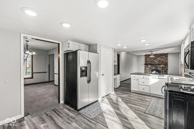 kitchen with dishwasher, stainless steel fridge, white cabinetry, and range