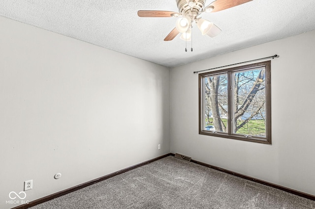 carpeted empty room featuring ceiling fan and a textured ceiling