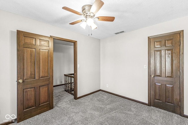 bedroom with ceiling fan, carpet floors, and a textured ceiling