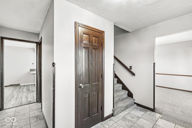 interior space featuring light tile patterned floors and a textured ceiling