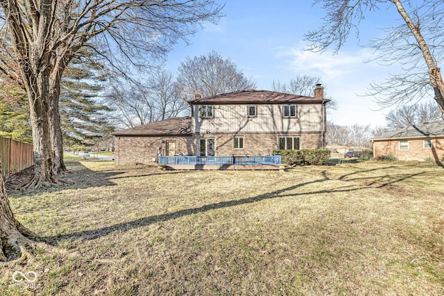 back of property featuring a lawn and a deck