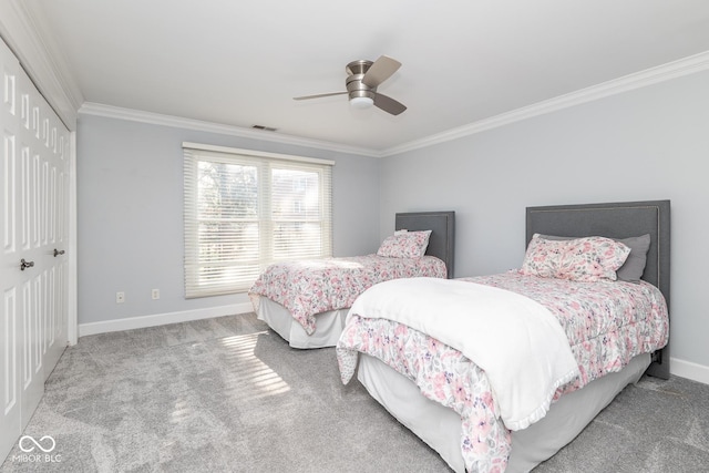 carpeted bedroom with ceiling fan, crown molding, and a closet