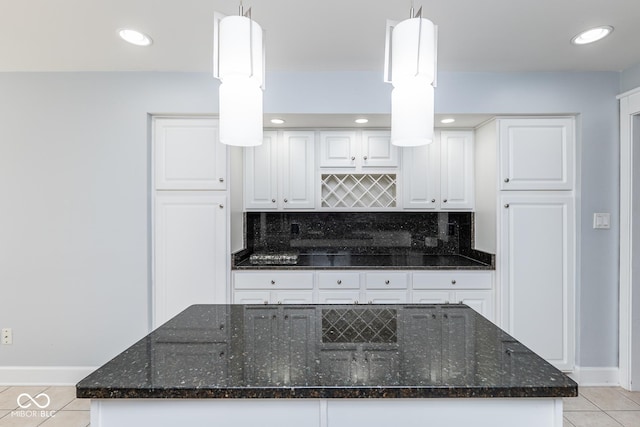 kitchen featuring pendant lighting, white cabinetry, and dark stone counters