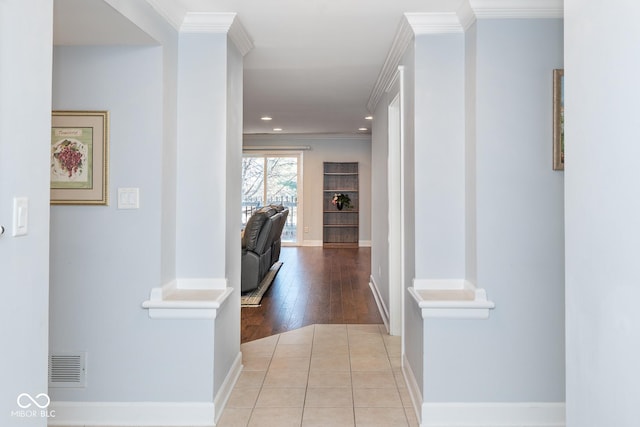 hall featuring crown molding and light tile patterned flooring