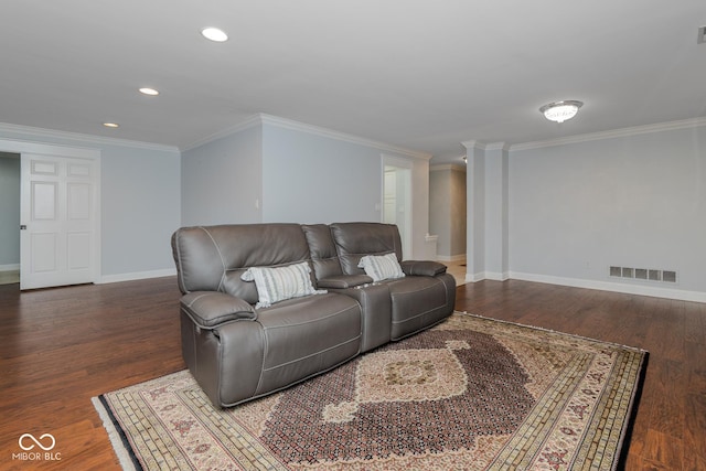 living room with decorative columns, dark hardwood / wood-style flooring, and ornamental molding