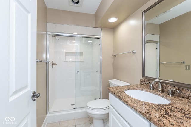 bathroom featuring vanity, a shower with door, tile patterned flooring, and toilet