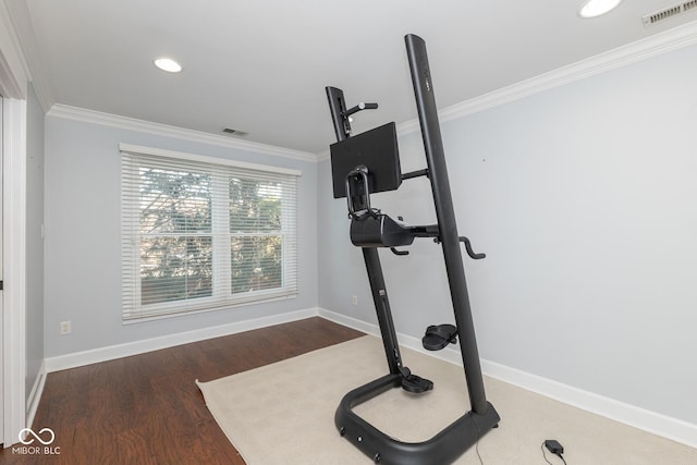 workout area featuring ornamental molding and dark wood-type flooring