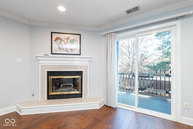 unfurnished living room featuring a tiled fireplace, crown molding, and hardwood / wood-style flooring