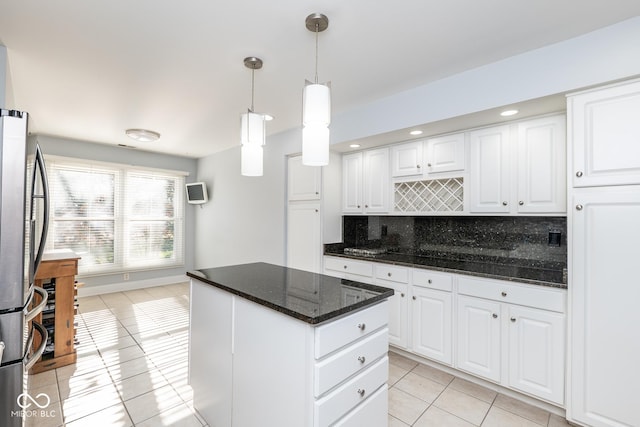 kitchen with decorative backsplash, white cabinets, light tile patterned flooring, and decorative light fixtures