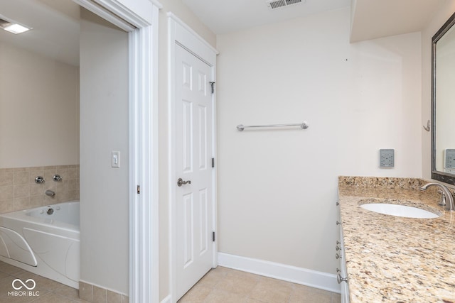 bathroom featuring tile patterned flooring, vanity, and a bath