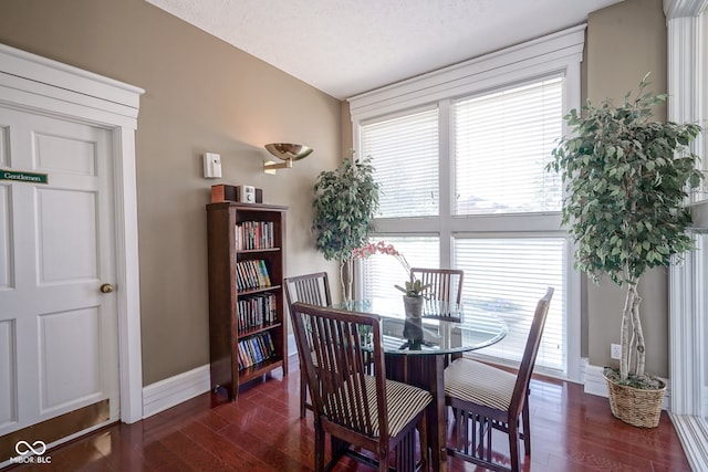 dining room with a textured ceiling and dark wood-type flooring