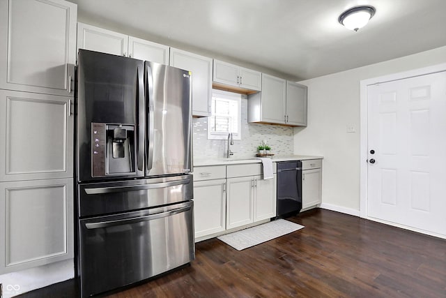 kitchen with dishwasher, white cabinets, sink, decorative backsplash, and stainless steel fridge