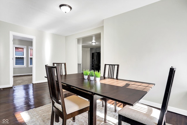 dining space with dark hardwood / wood-style flooring