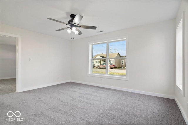 empty room featuring ceiling fan and carpet