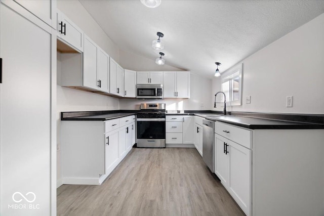 kitchen featuring white cabinetry, sink, stainless steel appliances, and a textured ceiling