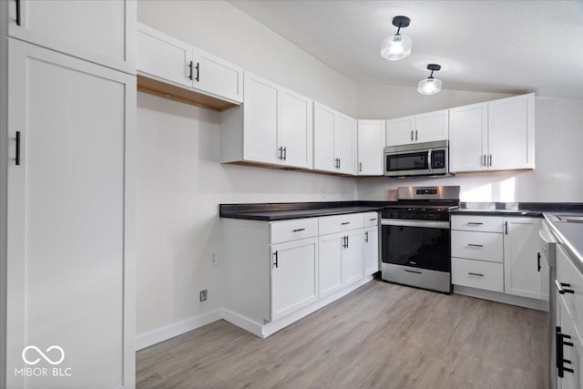 kitchen featuring decorative light fixtures, white cabinetry, stainless steel appliances, and light hardwood / wood-style flooring