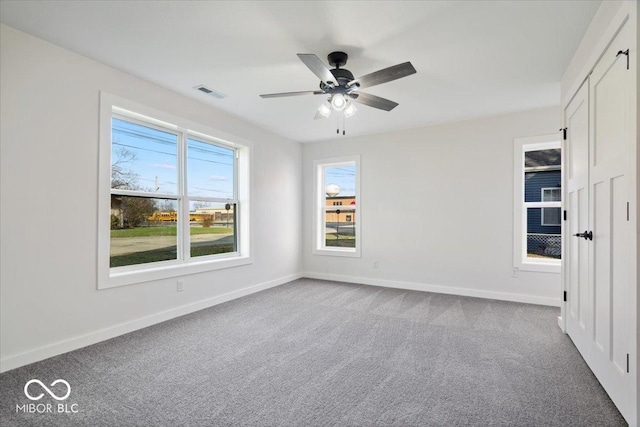 carpeted spare room with ceiling fan