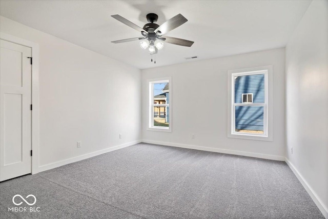 carpeted spare room featuring ceiling fan