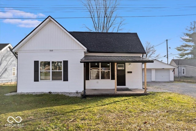 view of front of home featuring a garage, an outdoor structure, and a front yard