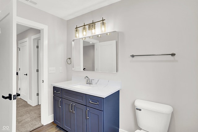 bathroom featuring wood-type flooring, vanity, and toilet