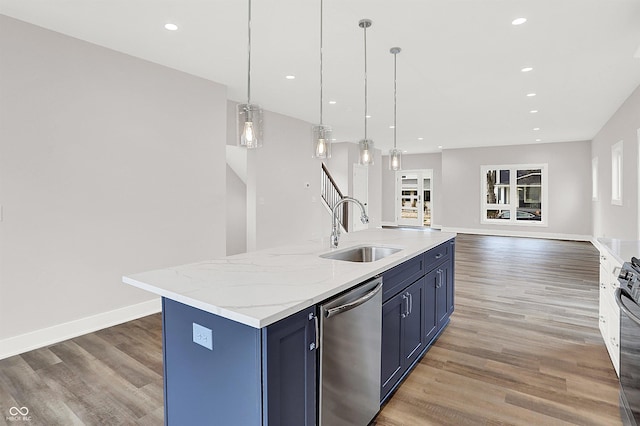 kitchen featuring pendant lighting, sink, stainless steel dishwasher, blue cabinetry, and an island with sink