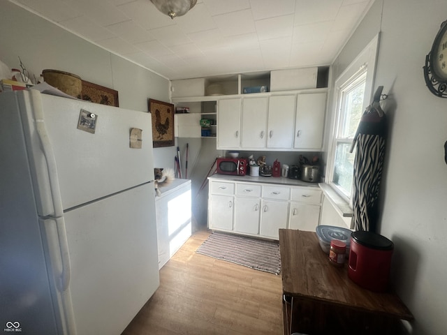 kitchen featuring white cabinets, light wood-type flooring, and white refrigerator