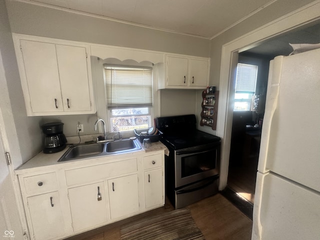 kitchen with white cabinets, black range with electric stovetop, sink, white fridge, and a healthy amount of sunlight