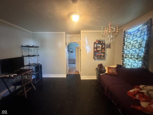 living room with a textured ceiling, dark hardwood / wood-style flooring, ornamental molding, and a notable chandelier