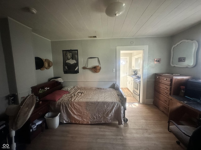 bedroom with connected bathroom, hardwood / wood-style flooring, and wooden ceiling