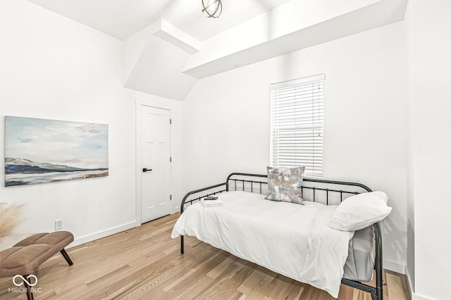 bedroom with vaulted ceiling and light hardwood / wood-style flooring