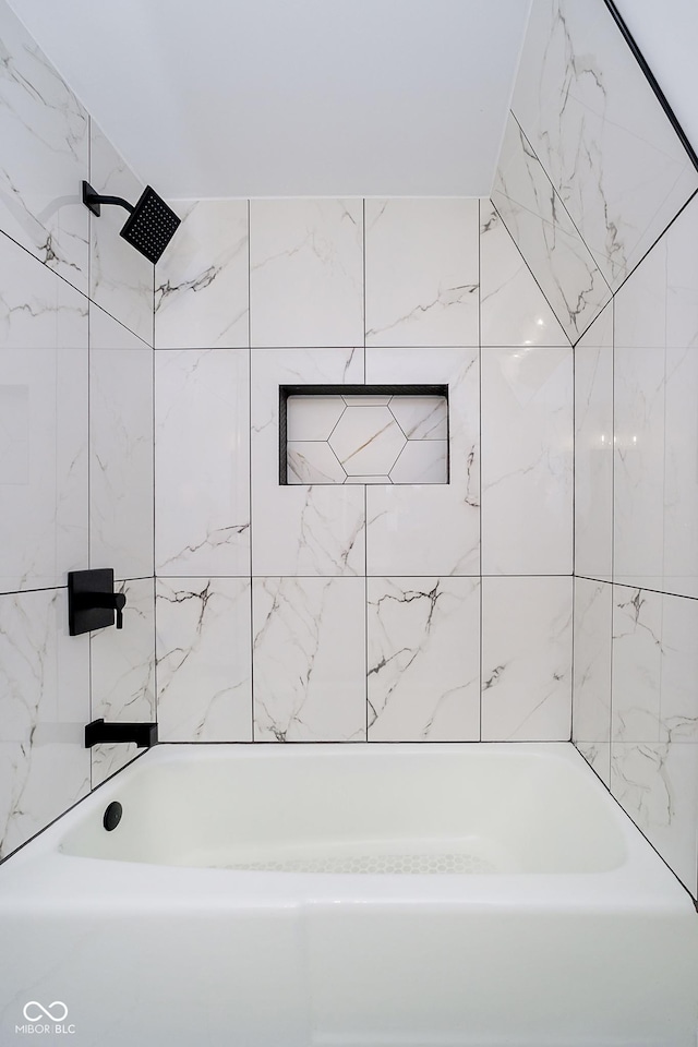 bathroom featuring tiled shower / bath