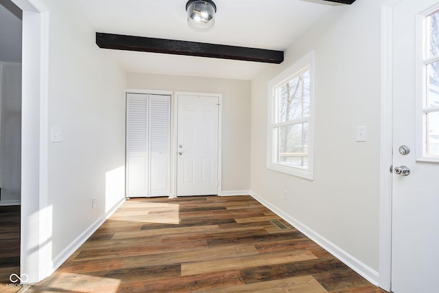 entrance foyer with dark wood-type flooring and beam ceiling