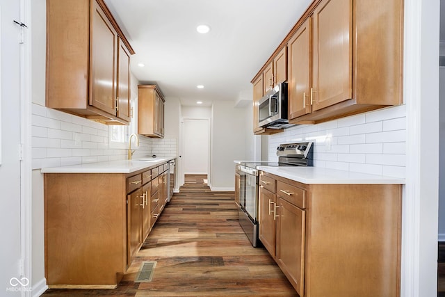 kitchen featuring dark hardwood / wood-style flooring, sink, backsplash, and stainless steel appliances