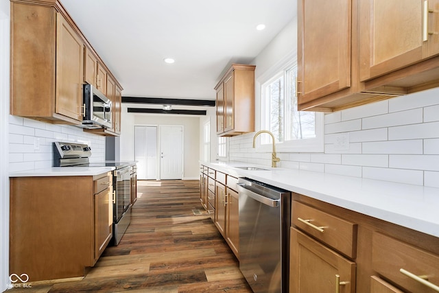 kitchen featuring tasteful backsplash, sink, dark wood-type flooring, and stainless steel appliances