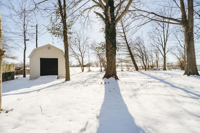 yard covered in snow with an outbuilding and a garage