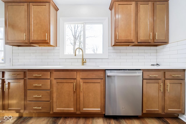 kitchen with hardwood / wood-style flooring, dishwasher, sink, and backsplash