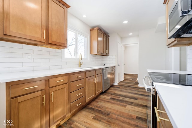 kitchen with stainless steel appliances, sink, backsplash, and dark hardwood / wood-style flooring