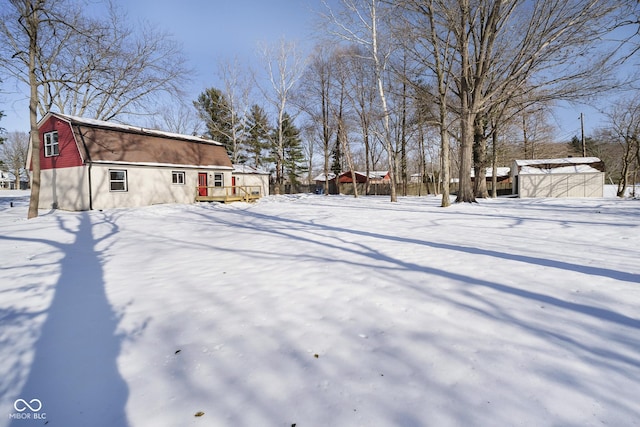 yard covered in snow featuring a storage shed