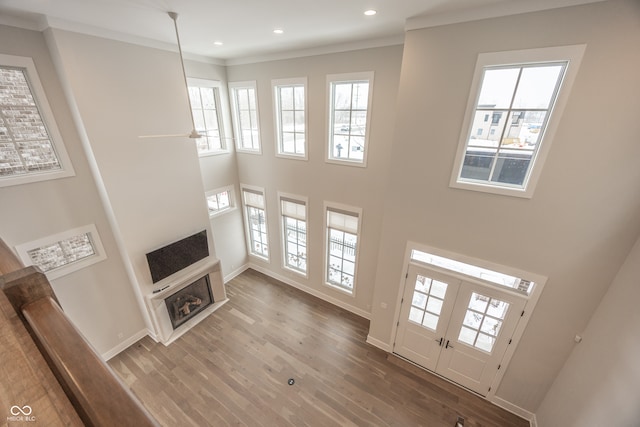 unfurnished living room with ornamental molding, hardwood / wood-style floors, plenty of natural light, and a fireplace