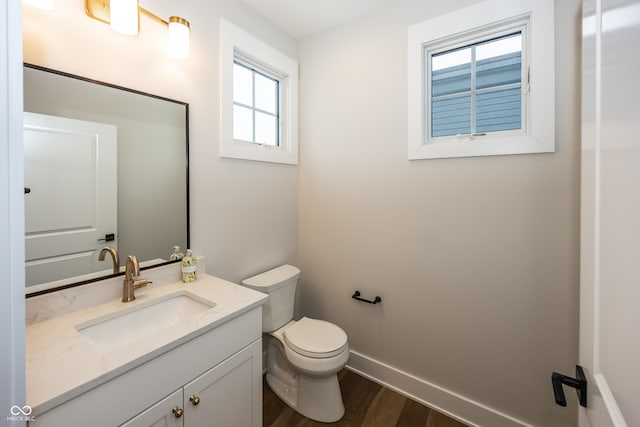 bathroom featuring hardwood / wood-style flooring, vanity, plenty of natural light, and toilet