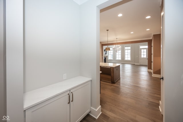 hallway featuring hardwood / wood-style flooring and a notable chandelier