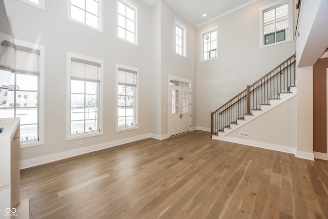 entryway featuring crown molding, plenty of natural light, and hardwood / wood-style flooring