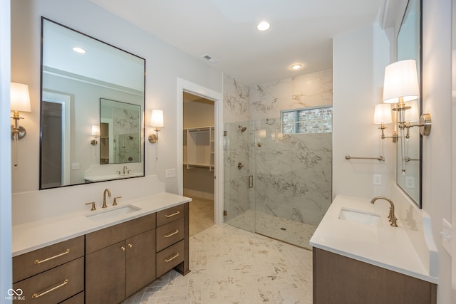 bathroom featuring a shower with door and vanity