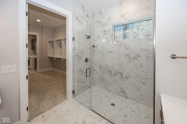 bathroom featuring washer / dryer and an enclosed shower